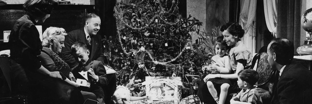 1940-es években egy család ül a karácsonyfa előtt ajándékokkal körülvéve