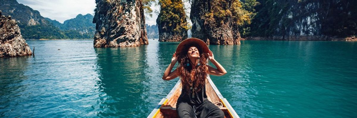 boldog nő ül egy csónakban nagy kalapban