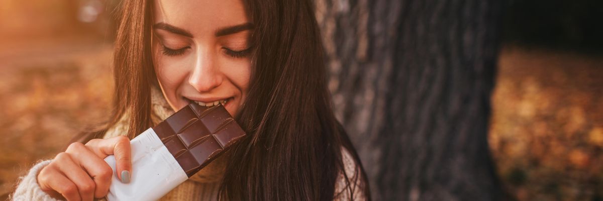 csokoládét majszol egy  fiatal nő