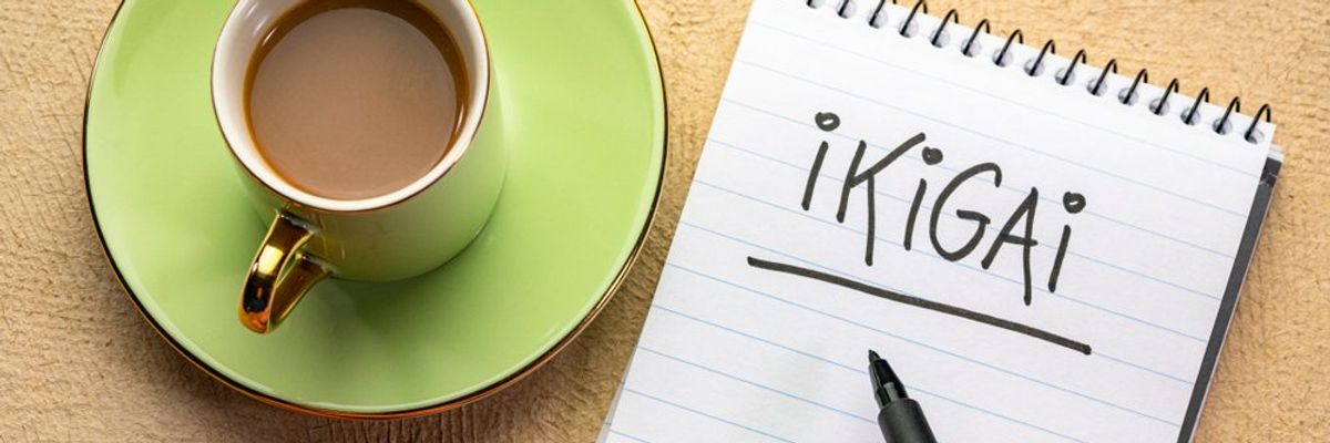 egy csésze kávé mellett egy ember a noteszébe azt írta, hogy ikigai
