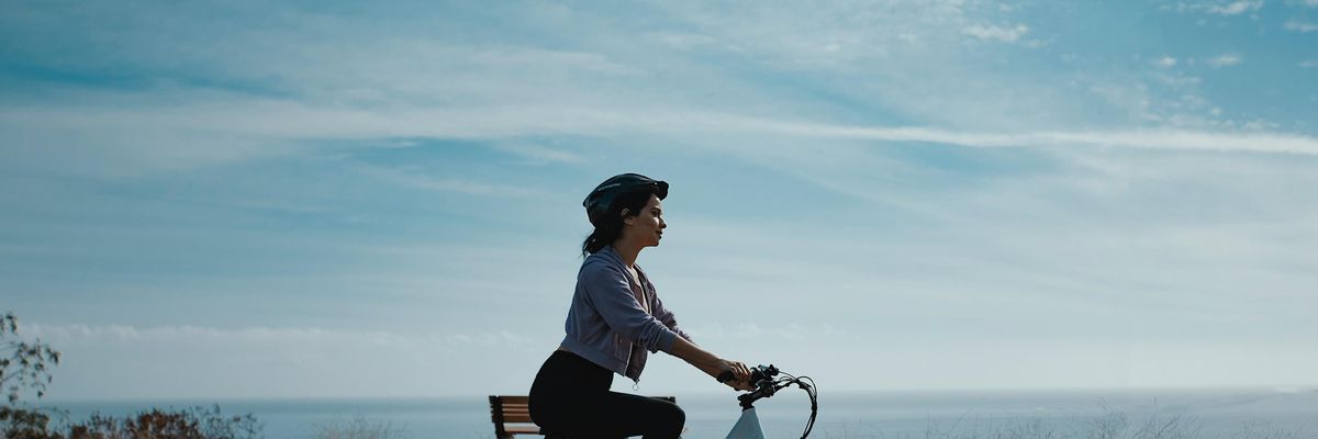 Egy nő, aki biciklizik.