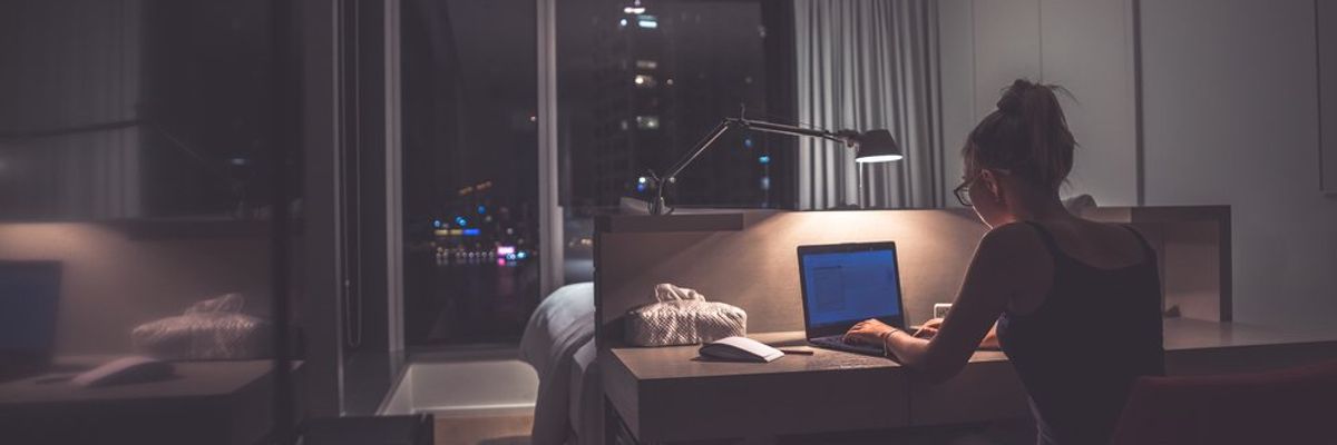 egy nő éjszaka dolgozik a laptopján