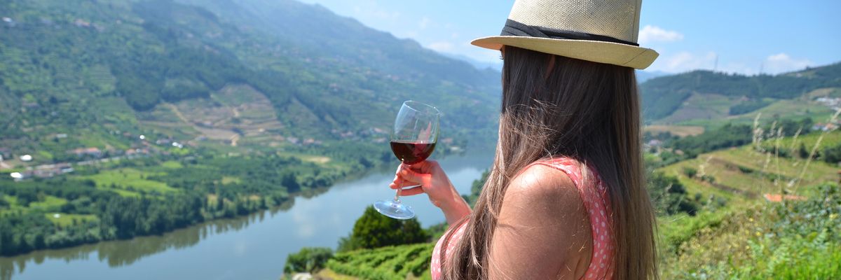 egy pohár borral álló nő Douro régióban