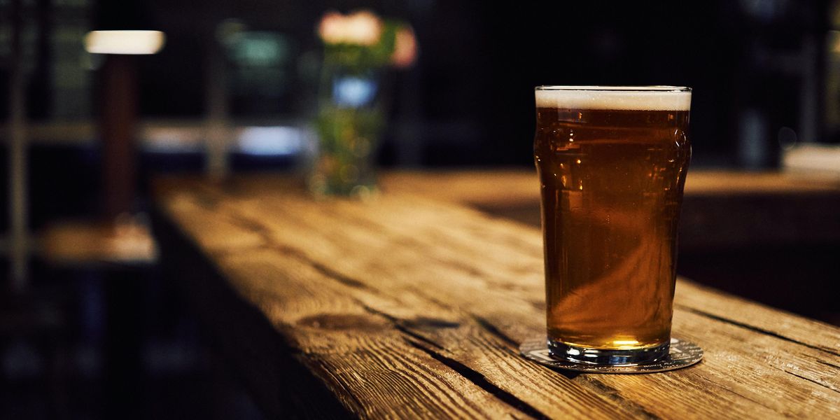 egy teli korsó sör áll a fapulton, alatta poháralátét 