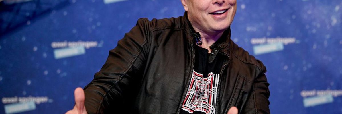 Elon Musk mosolyog és pózol.