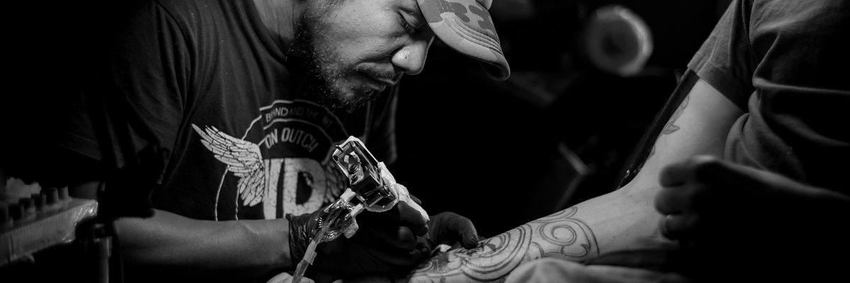 fekete fehér fotó egy tetováló fickóról sapkában