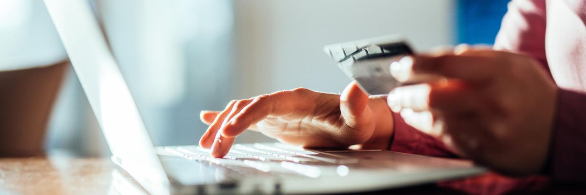 férfi kezek hitelkártya bankkártya laptop számítógép online fizetés asztal rózsaszín ing