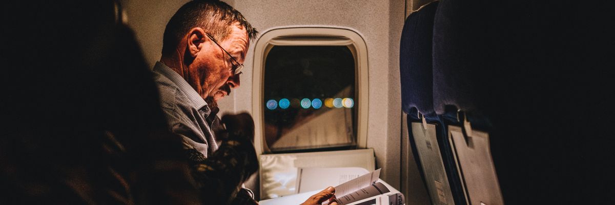 Férfi olvas a repülőn.