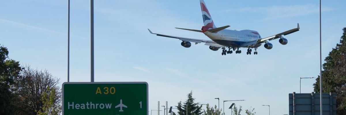 Heathrow repülőtér táblája és egy British Airways repülő