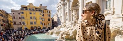 egy nő ül Rómában a szökőkút szélén nyáron