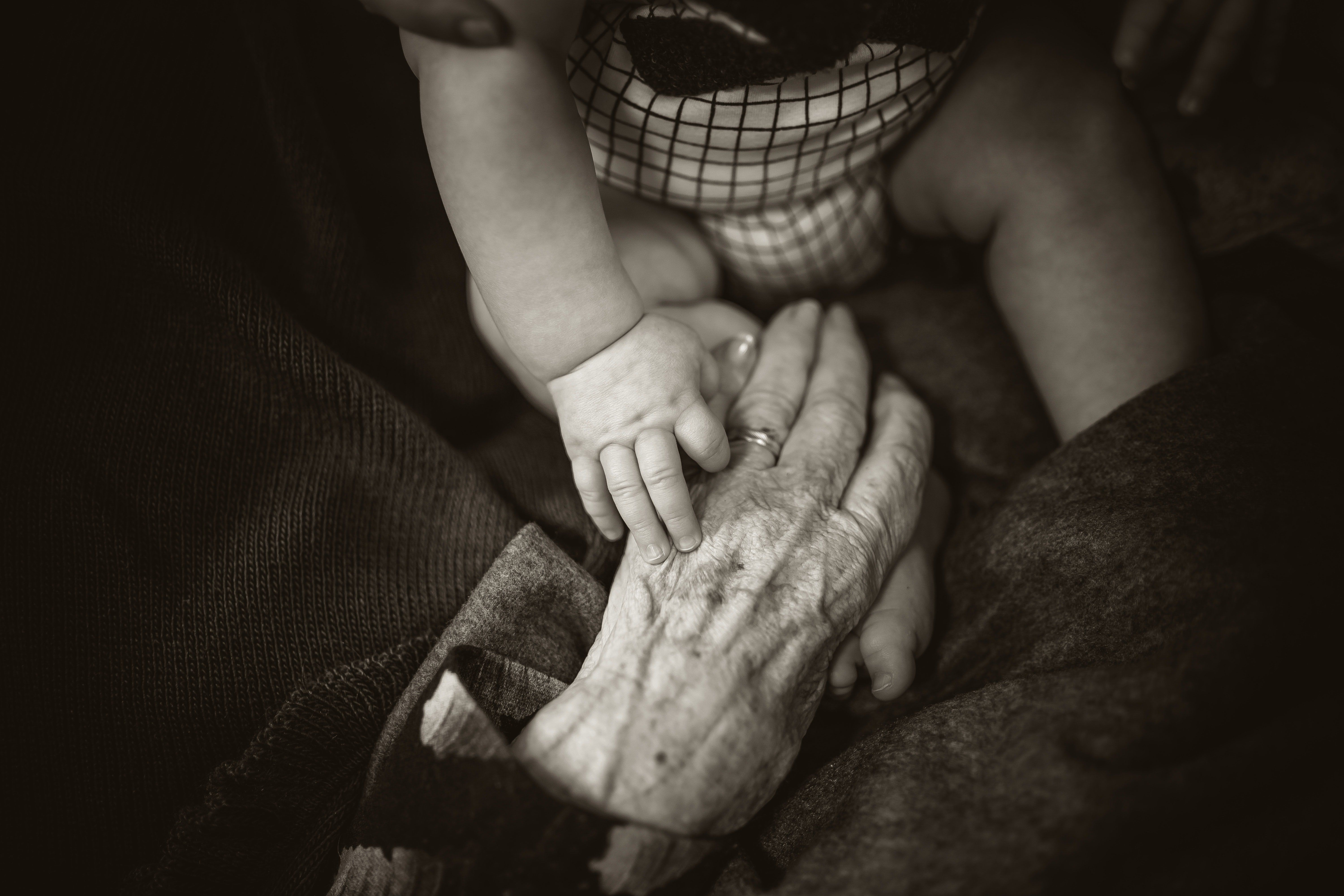 Egy baba és egy idős ember keze