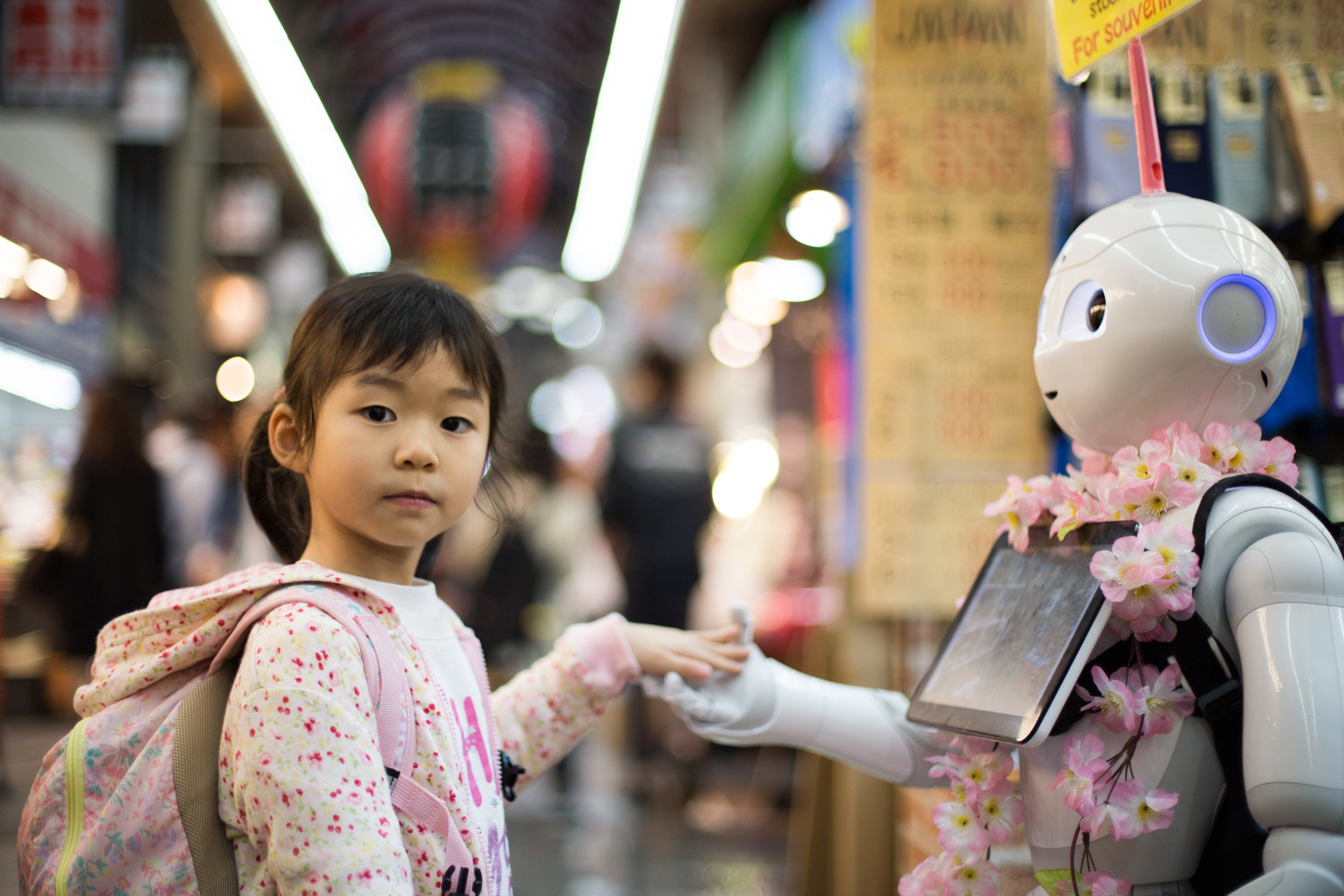 Kislány egy robot kezét fogja