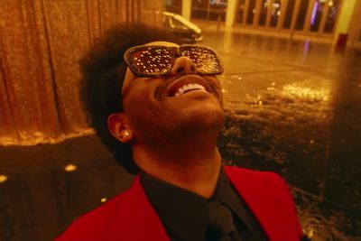The Weeknd a Blinding Lights videoklipjében napszemüvegben nézi a fényeket