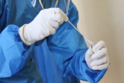 orvos vizsgáló kék köpeny covid-19 teszt gumikesztyű ember