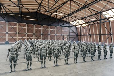 humanoid robotok egy katonai sátorban sorakoznak