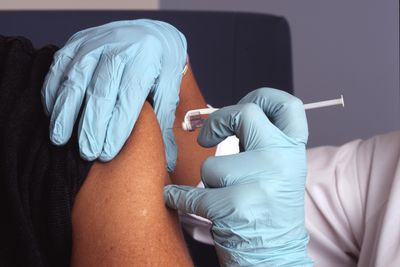 Egy nővér védőoltást ad be egy páciensnek