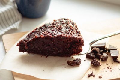 Vegán csokoládés sütemény egy fatálcán, mellett csoki darabok