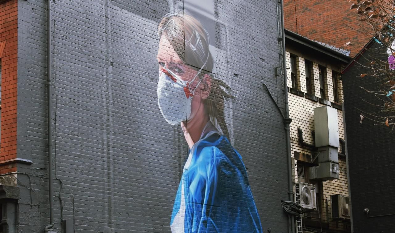 Egy maszkos nővér graffitije egy téglafalon