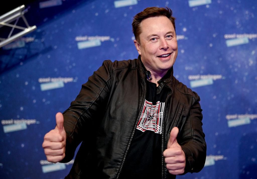Elon Musk mosolyog és pózol.