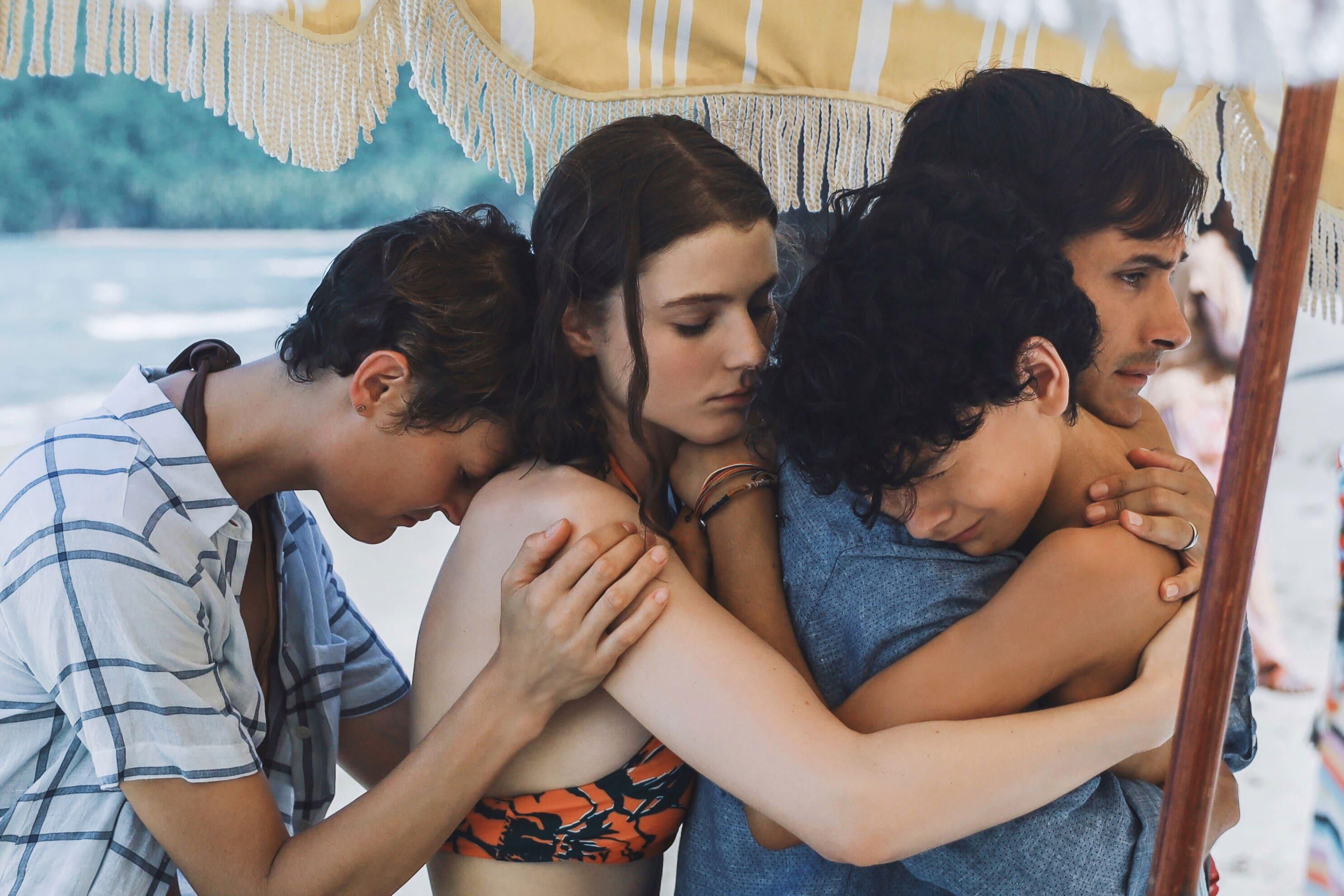 Vicky Krieps, Thomasin McKenzie,  Luca Faustino Rodriguez és Gael García Bernal az Idő című film egyik jelenetében ölelkeznek.