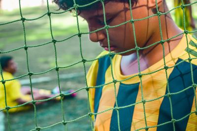 Photo of a young footballer boy using his phone before the match starts