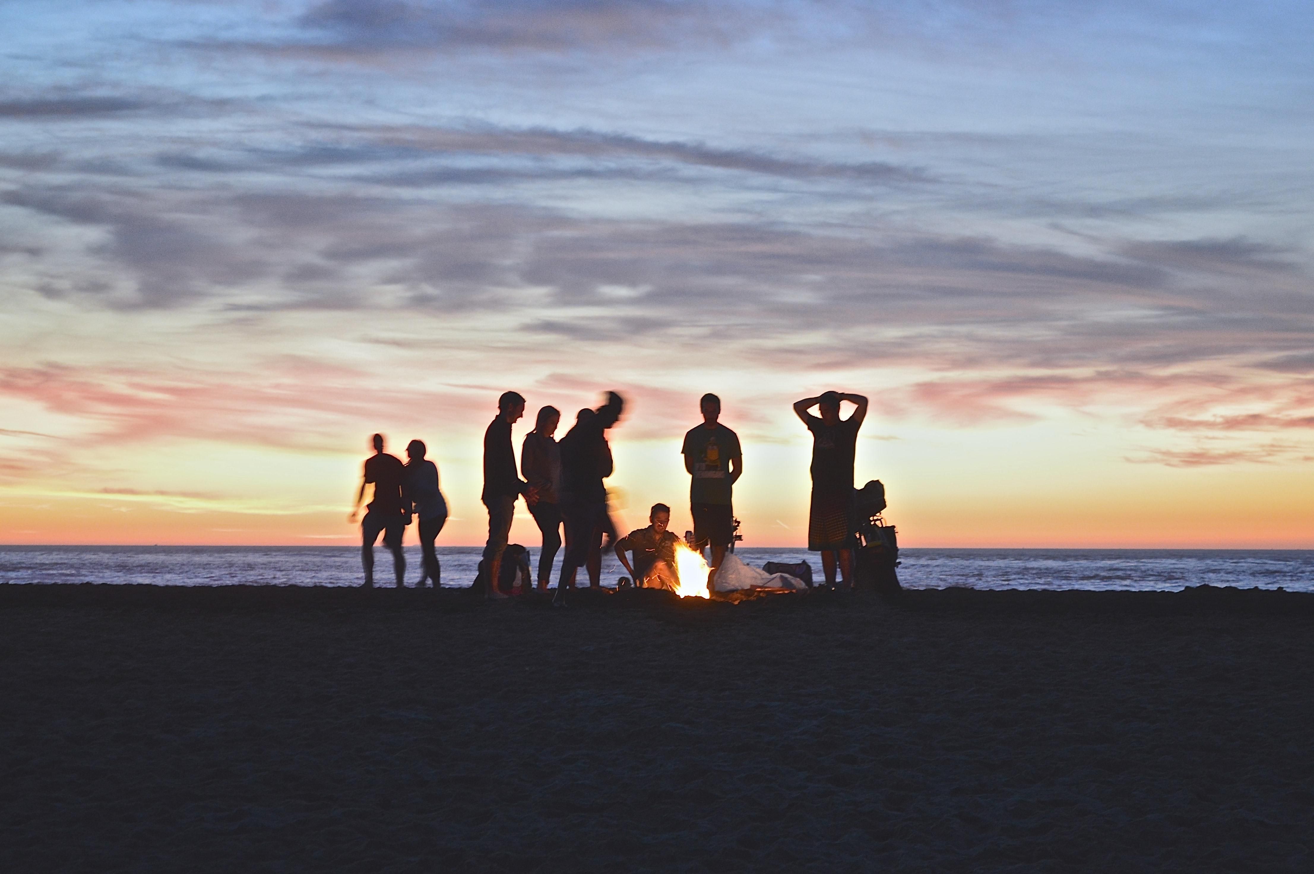 egy baráti társaság a tengerparton a tűz körül