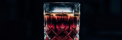 clear drinking glass filled with red liquid whisky