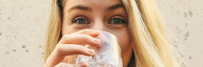 vizet iszik egy nő üvegpohárból