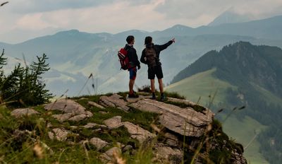 Két ember túrázás közben szép tájat néz 