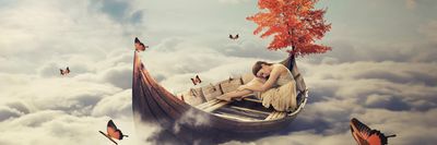 álomkép, melyen egy nő ül a csónakban a felhők között, mellette fa és pillangók