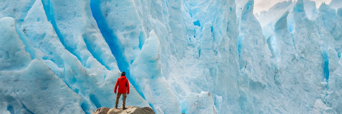 jéghegy férfi piros kabát sziklák part antarktisz
