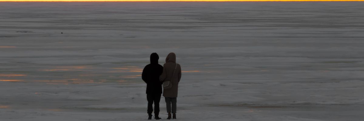 két ember sétál a naplementében