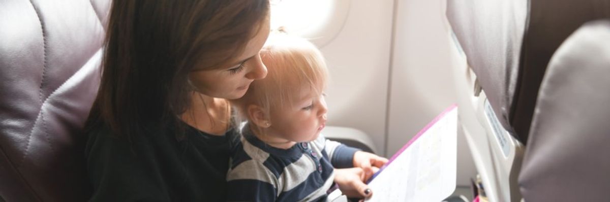 Kisgyerek az anyukája ölében a repülőn