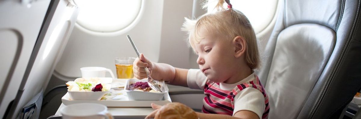 kislány eszik a repülőn