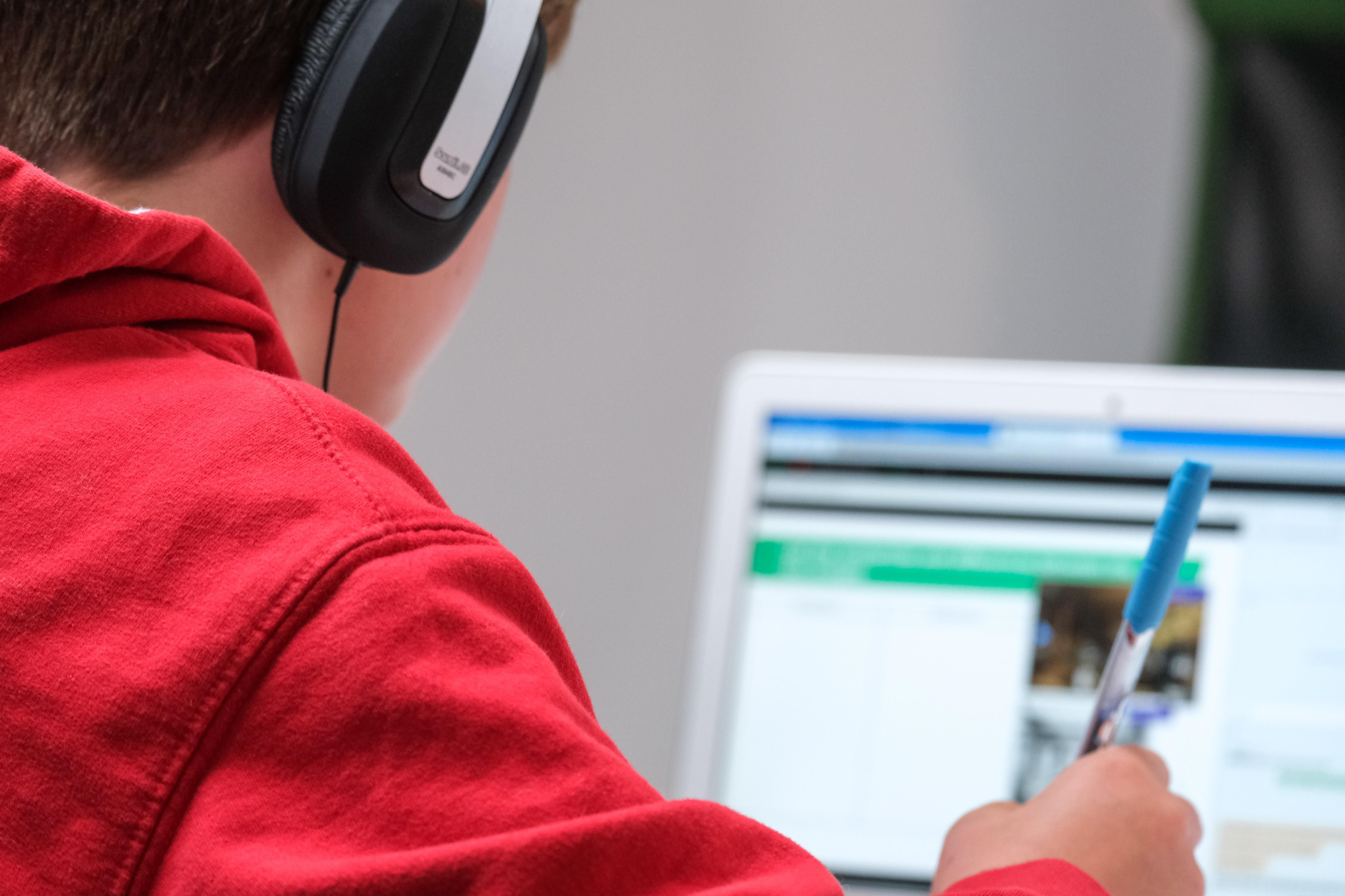 Egy fiú online tanórát néz a számítógépén.