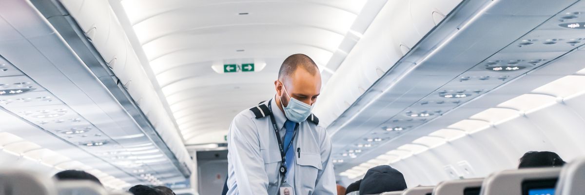 man in blue dress shirt standing in airplane
