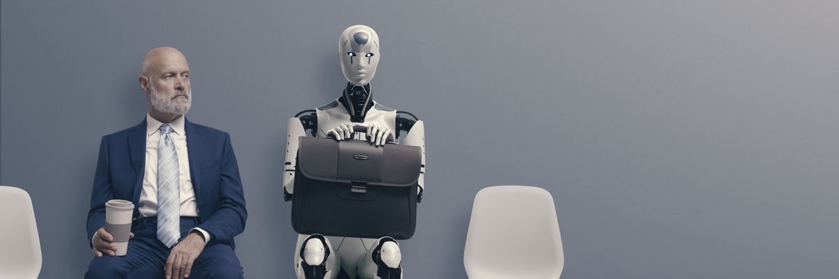 öltönyös férfi és robot ülnek egymás mellett