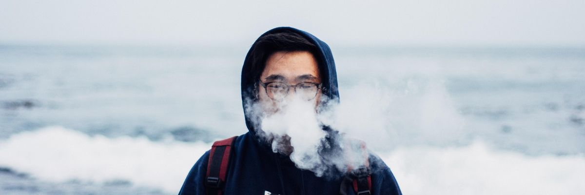 person in black hoodie smoking