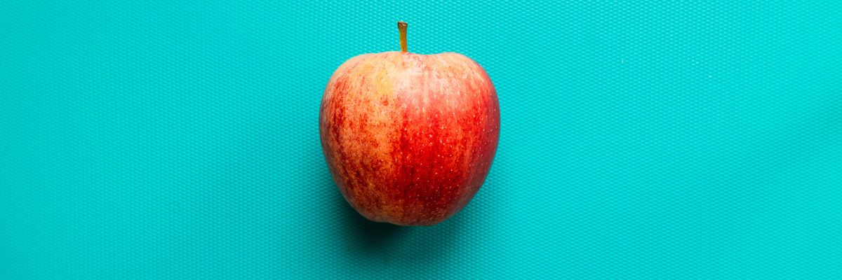 red apple fruit on blue surface