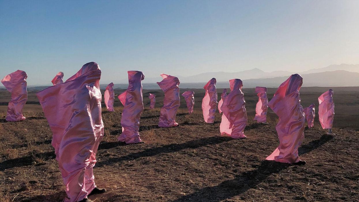 rózsaszín zsákokban állnak emberek egy mezőn