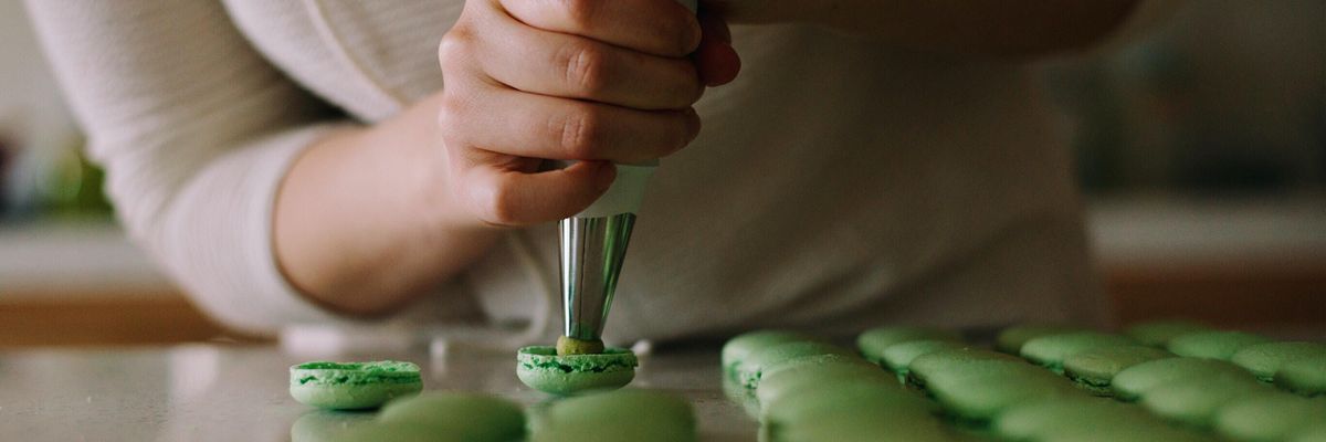 selective focus photography of woman putting icing on cupcakes