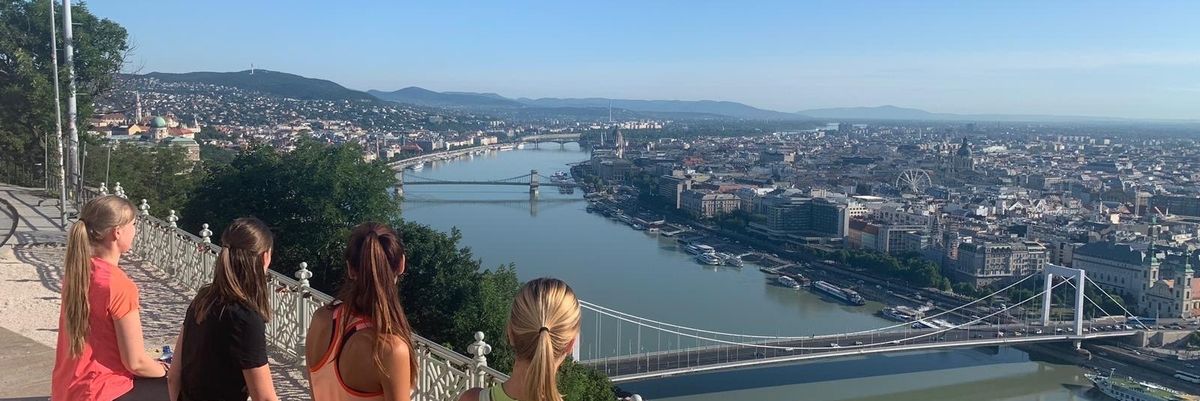 Sportruházatban üldögélő nők nézik a budapesti kilátást 