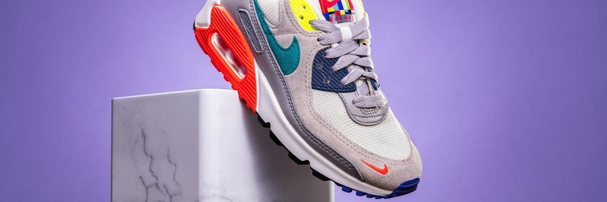 színes Nike cipő egy márvány állvánnyal lila háttér előtt