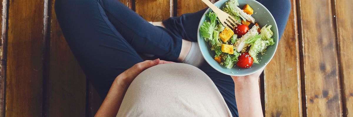 terhes nő egy tál salátával