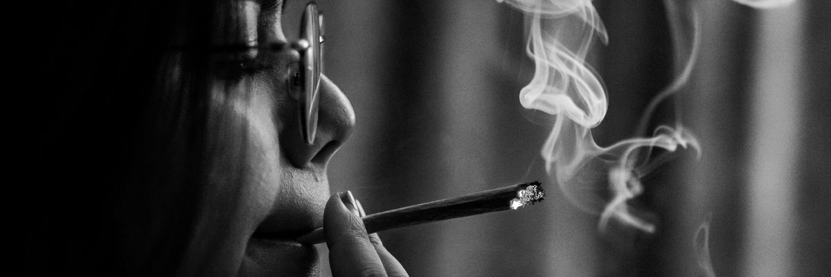 woman smoking cigarette in grayscale photography